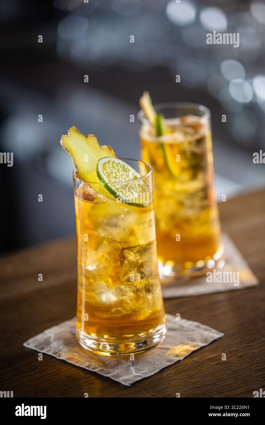 Zwei Gläser Whisky und Ingwer-Limonade mit Eis und Scheiben von frischem Ingwer und Limette Stockfoto