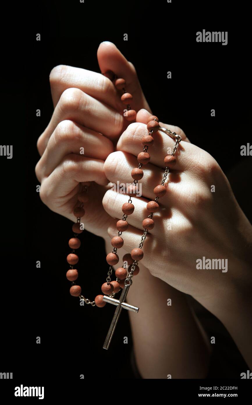 Beten mit einem Rosenkranz. Frauenhände mit Rosenkranz auf