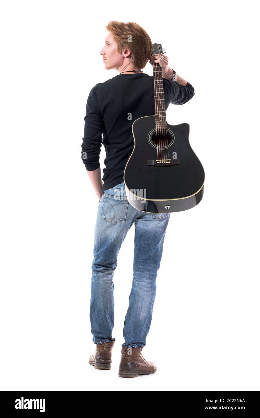 Rückansicht des jungen Rockmusikers, der Gitarre auf der Schulter trägt und nach oben und weg schaut, um Inspiration zu erhalten. Ganzkörperlänge isoliert auf weißem Hintergrund. Stockfoto