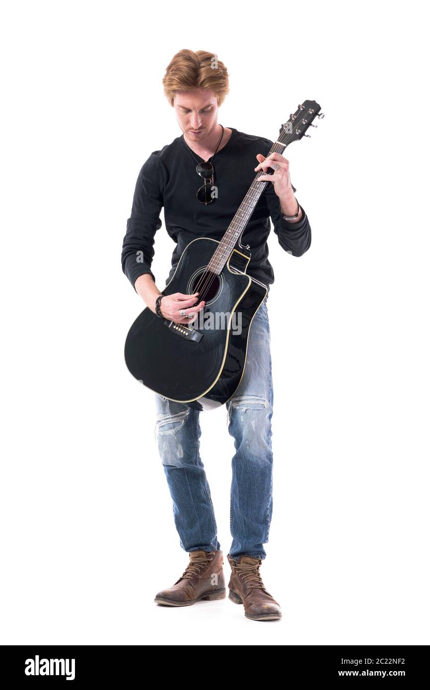 Junge gutaussehende stilvolle Rocker Mann Proben schwarzen akustischen  Gitarre Blick nach unten. Ganzkörperlänge isoliert auf weißem Hintergrund  Stockfotografie - Alamy