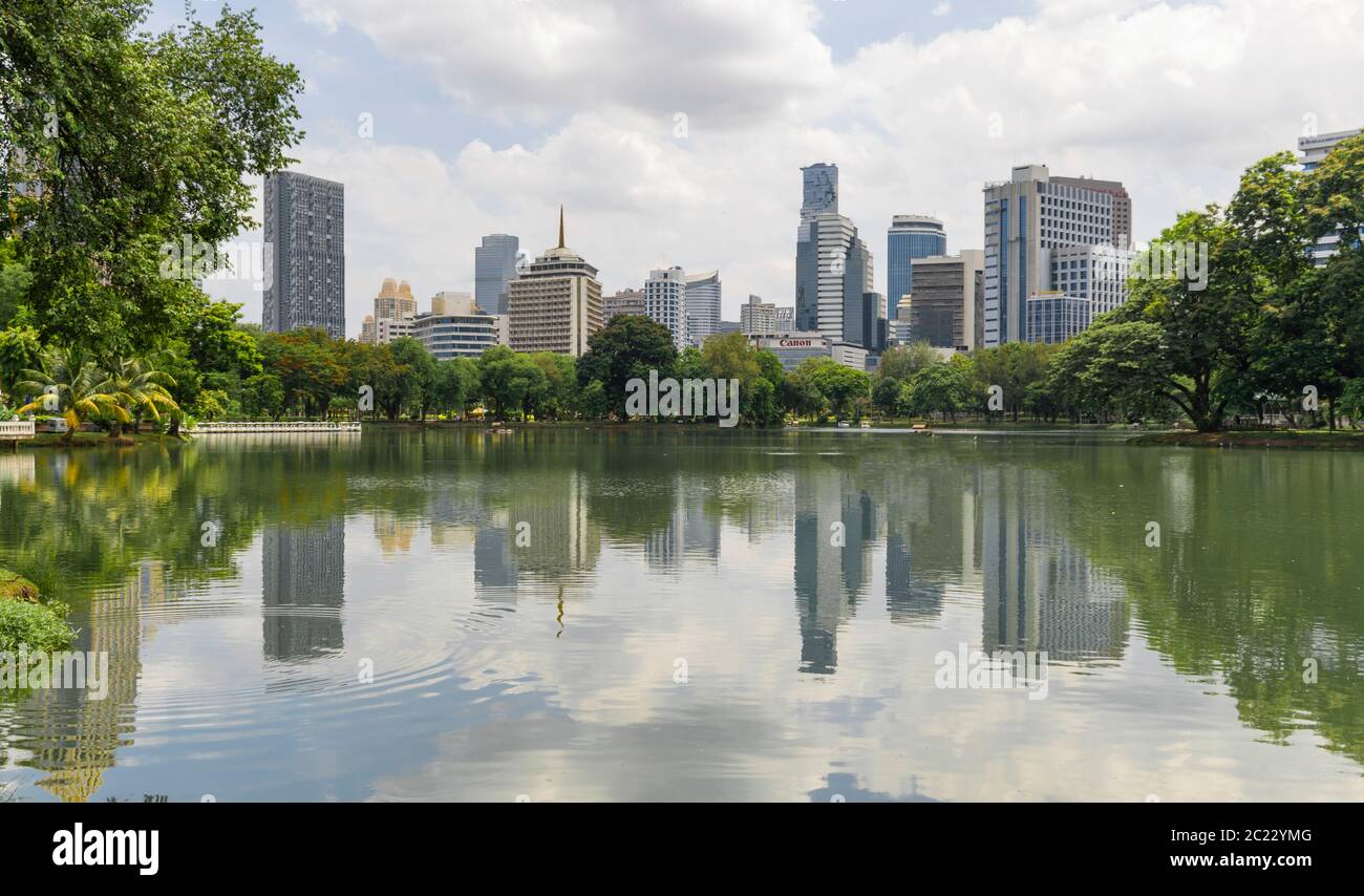 Bangkok 1: Bangkok / Thailand - 18. Juli 2019: Stadtreflexion an einem See im Lumphini Park in Bangkok. Stadtbild mit einigen Wolkenkratzern. Stockfoto