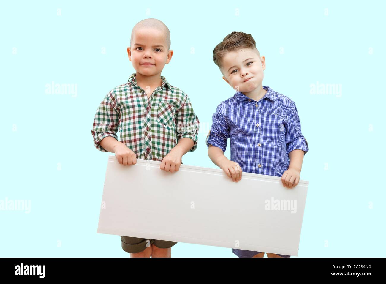 Porträt von zwei Jungen mit weißem Schild auf isoliertem Hintergrund Stockfoto