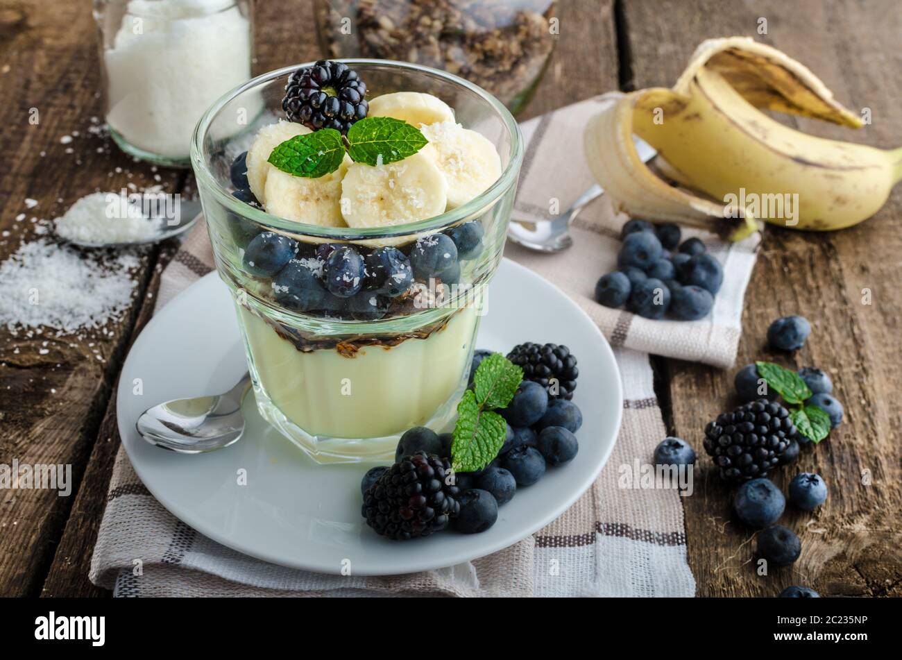 Vanillepudding mit Beeren und Minze auf Holz Schreibtisch Stockfoto