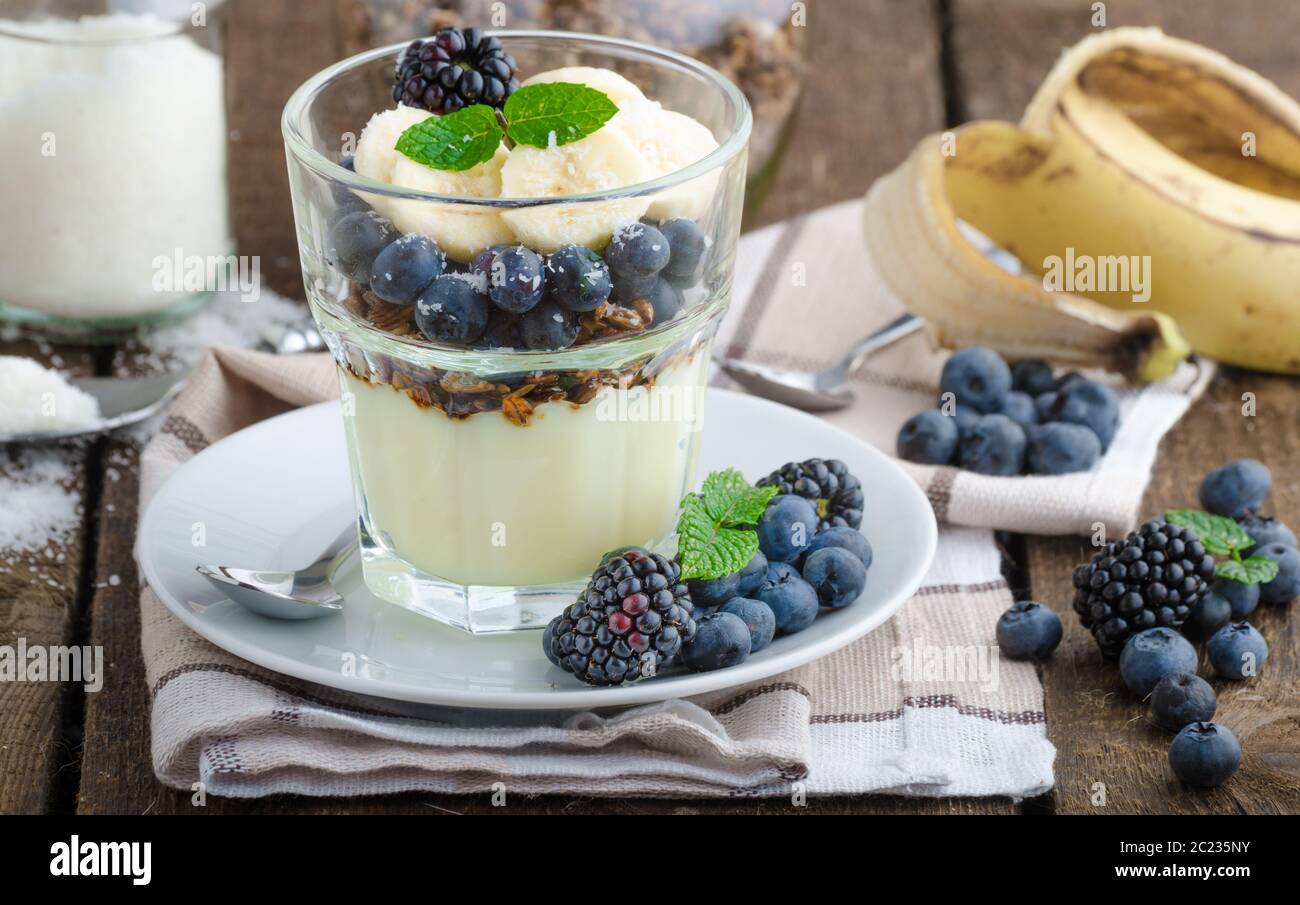 Vanillepudding mit Beeren und Minze auf Holz Schreibtisch Stockfoto