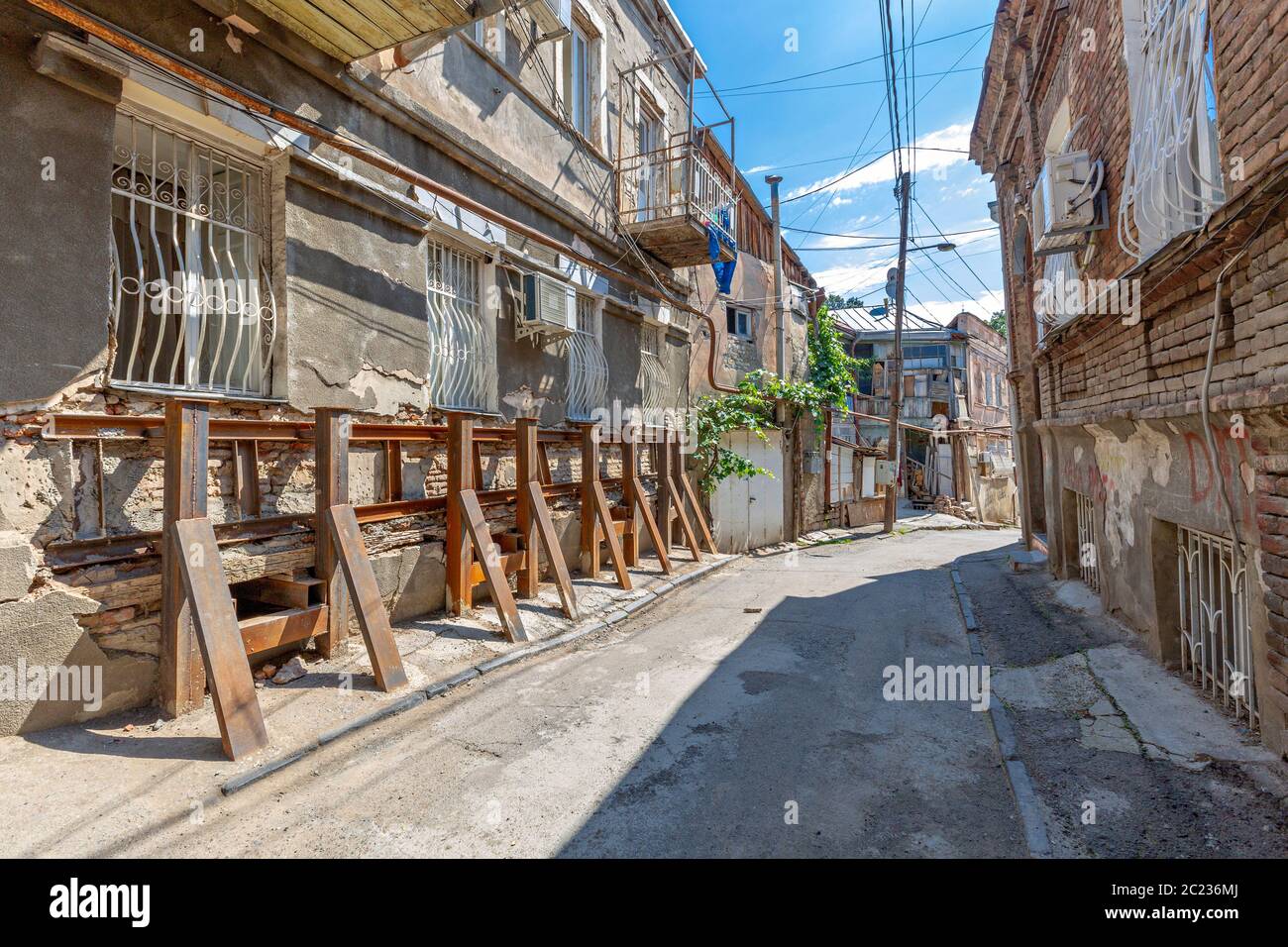 Halten der alten Häuser mit Stahlstangen für die Restaurierung in der Altstadt von Tiflis, Georgien Stockfoto