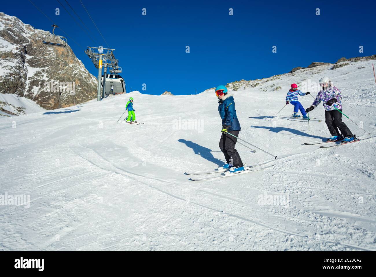 Gruppe von Kindern Ski-Abfahrt auf Alpine Piste in Schulbildung zusammen einer nach dem anderen Stockfoto