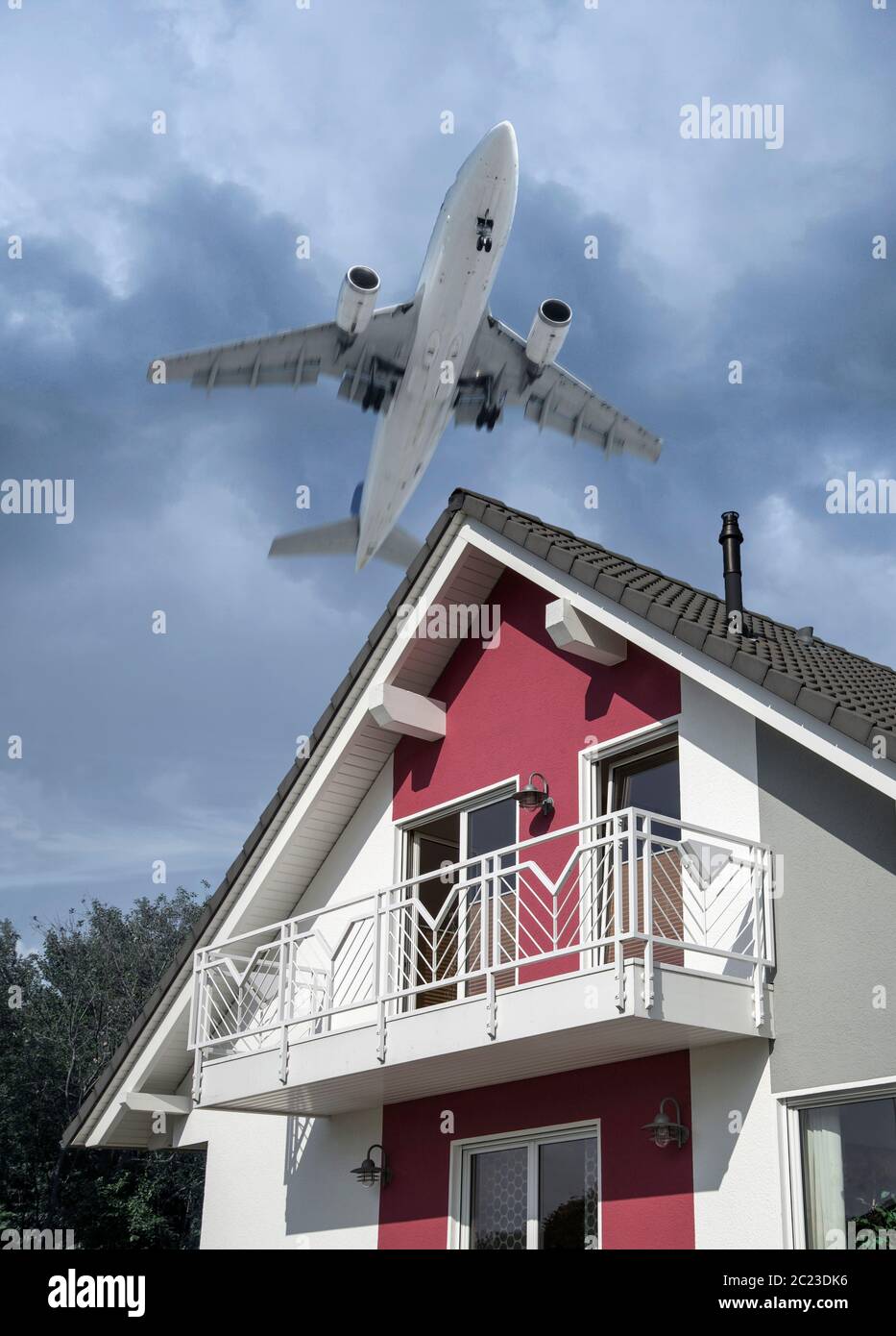 Ein Flugzeug während des Aufstiegs über ein Einfamilienhaus.Digital Composite (DC) Stockfoto