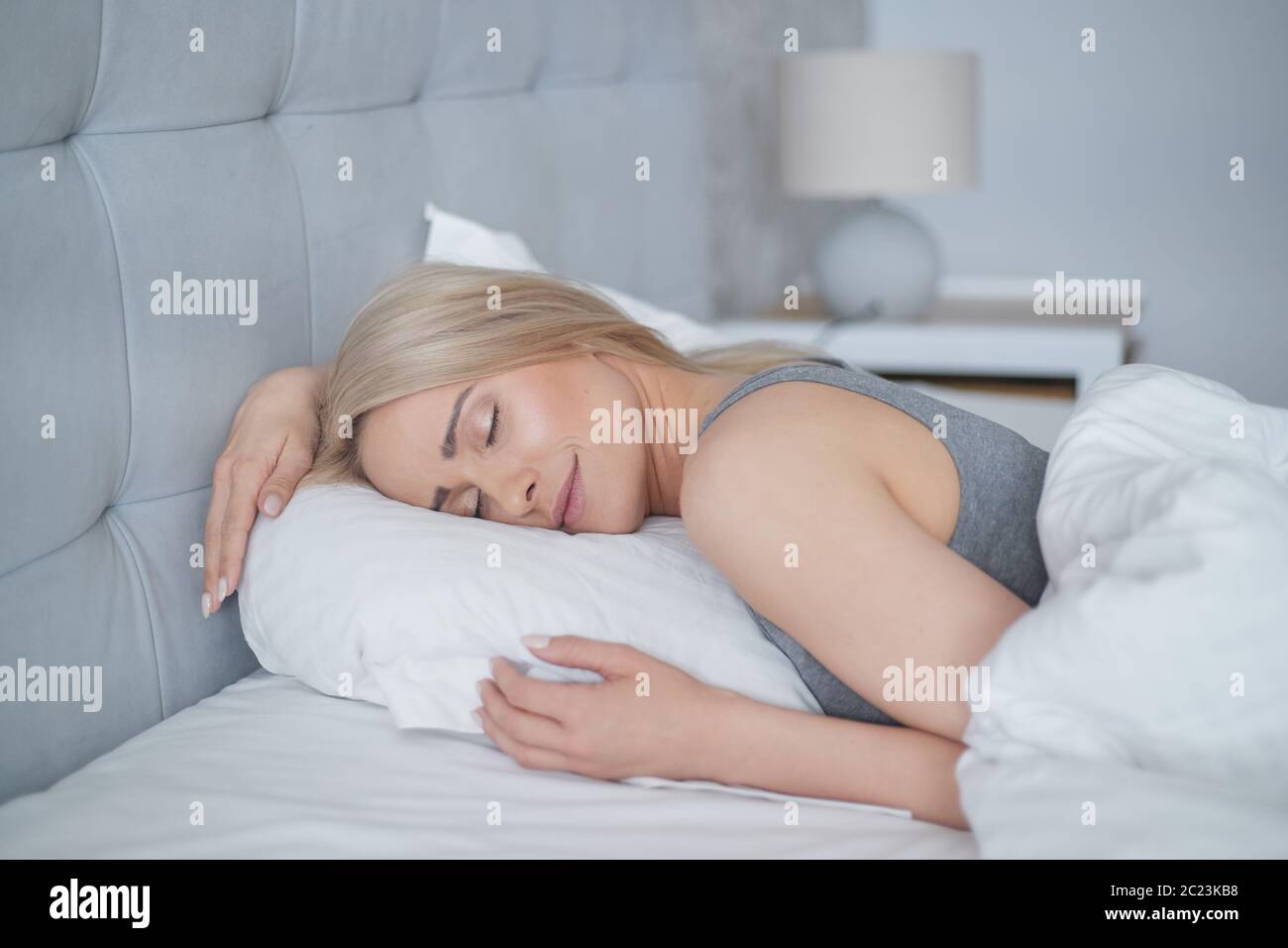 Junge hübsche blonde Frau schlafen in ihrem Schlafzimmer Stockfoto