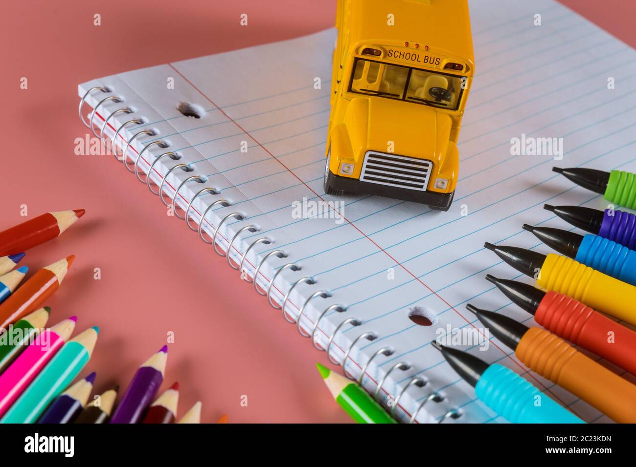 Gelbe Schulbus auf Buntstifte und Tastatur, Zurück zur Schule Stockfoto