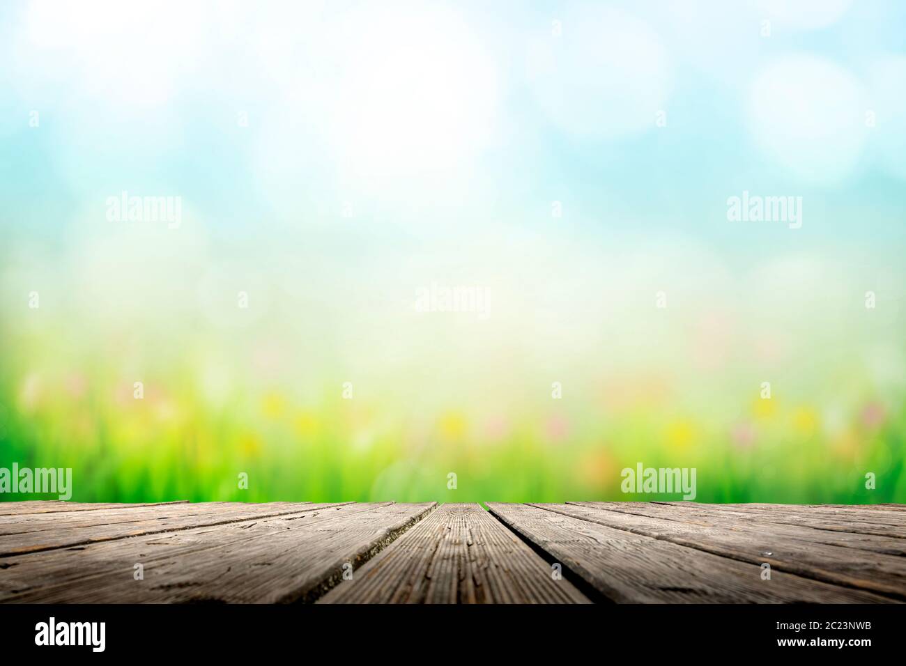 Hintergrund mit sonniger Wiese über Holzdeck Stockfoto