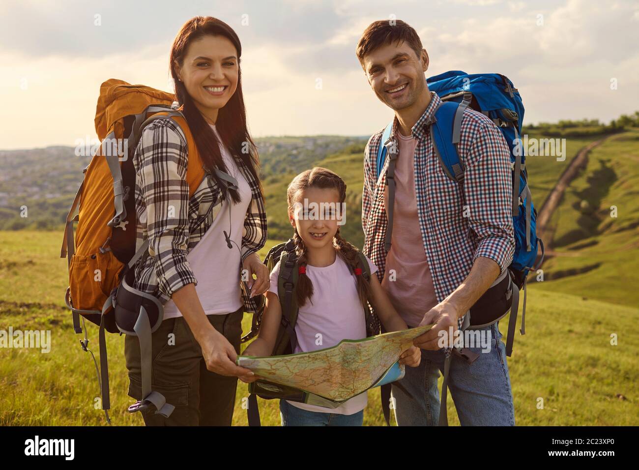 Glückliche Familie mit Rucksäcken Wandern in der Natur. Stockfoto