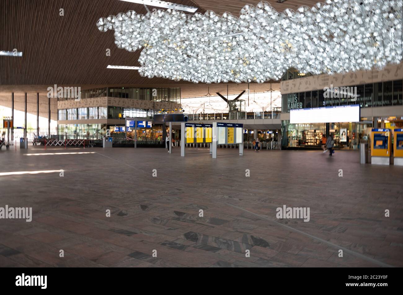 Hauptatriumhalle des Rotterdamer Hauptbahnhofs in den Niederlanden. Geschäfte und Menschen sind während der Covid-Sperre gut sichtbar Stockfoto