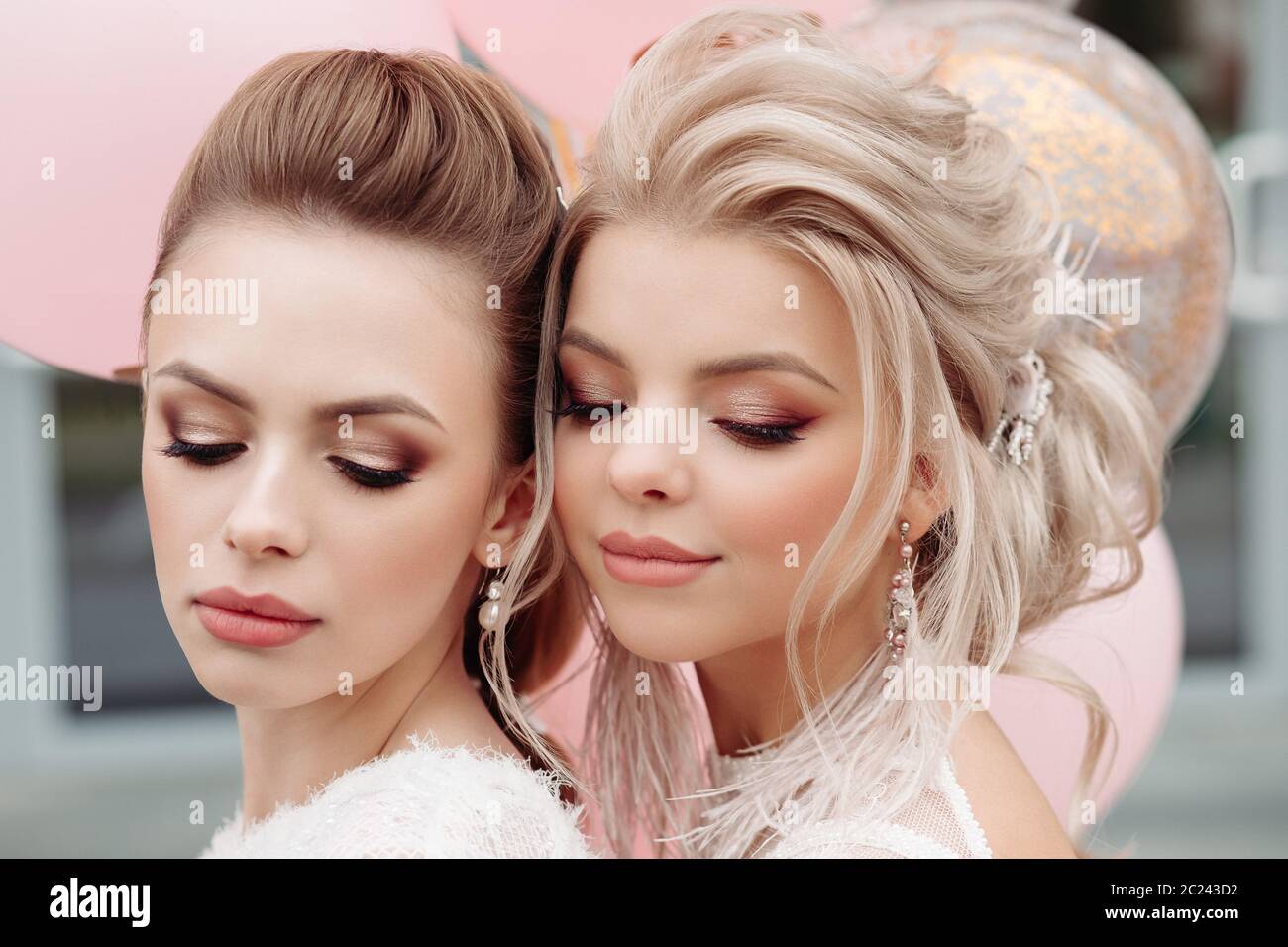 Zwei wunderschöne Modelle, die mit Make-up und Frisur in Weiß. Stockfoto