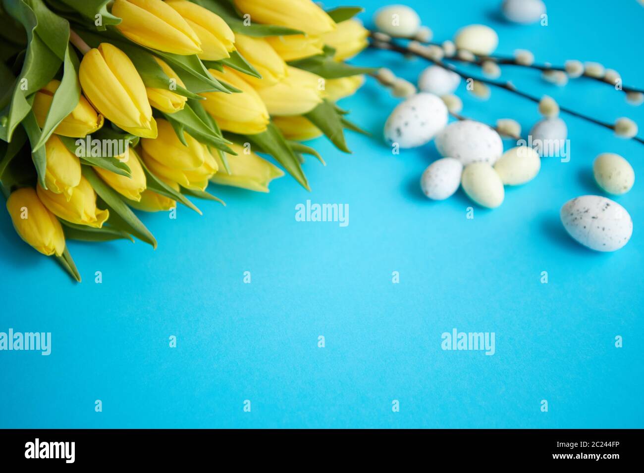 Urlaub contept Dekoration mit Ostereiern und gelbe Tulpen über Blau Stockfoto