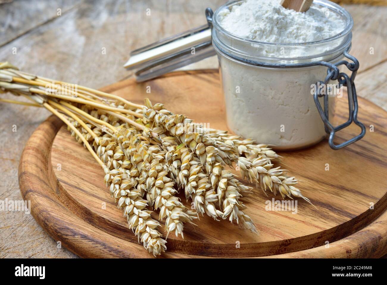 Mehl, Brot und Getreide auf einem Holzbrett. Stockfoto