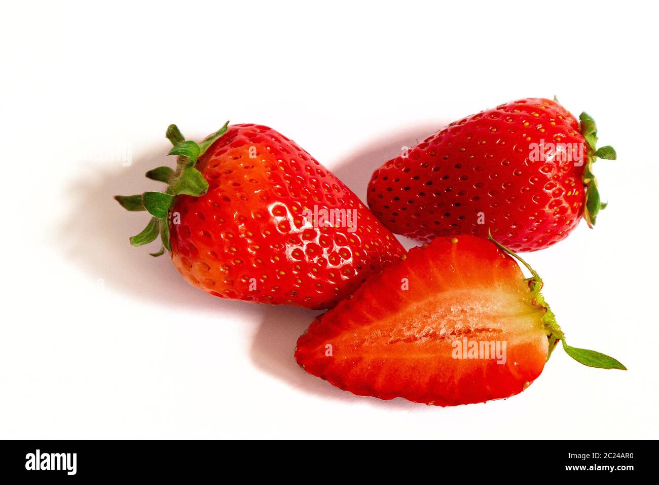 Zweieinhalb rote Erdbeeren Früchte, Nahaufnahme isoliert auf weißem Hintergrund Stockfoto