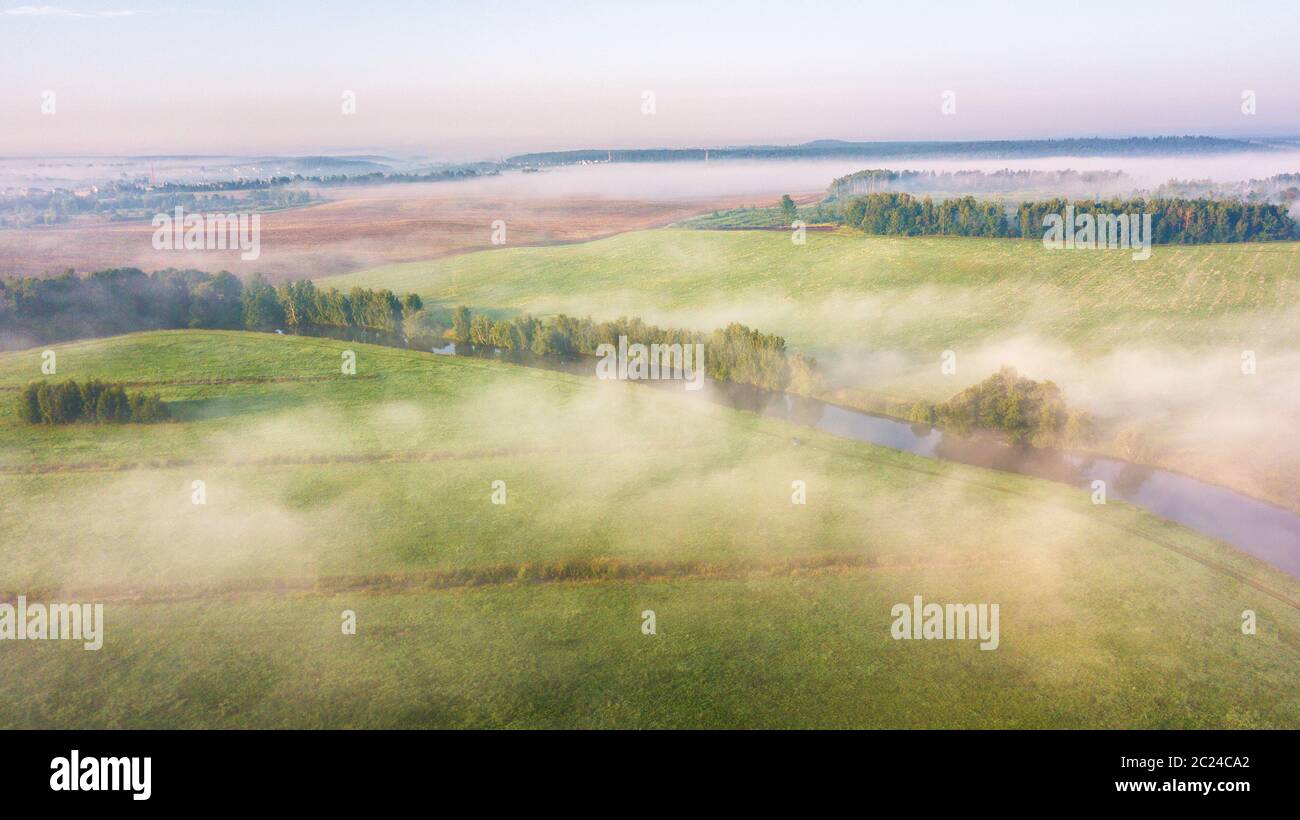 Sommer Natur Landschaft Luftbild Panorama. Morgennebel über den Fluss, Wiese und Wald. Natur Sonnenlicht Szene bei Nebel Sonnenaufgang. Belarus, Europa Stockfoto