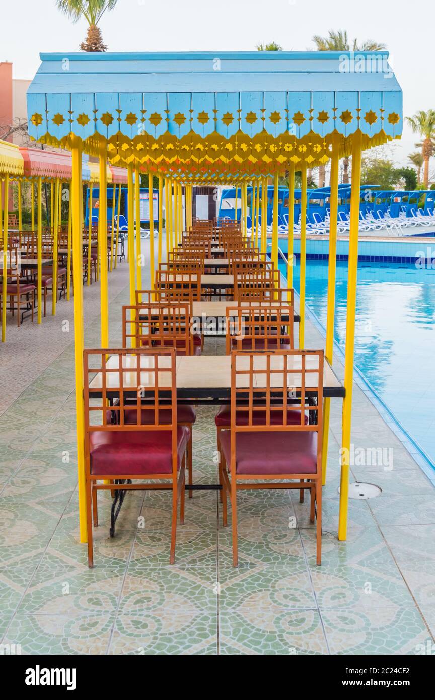 Das hölzerne Restaurant Terrasse mit Tischen mit vier Sitze mit einem kleinen Dach gegen die Sonne. Stockfoto