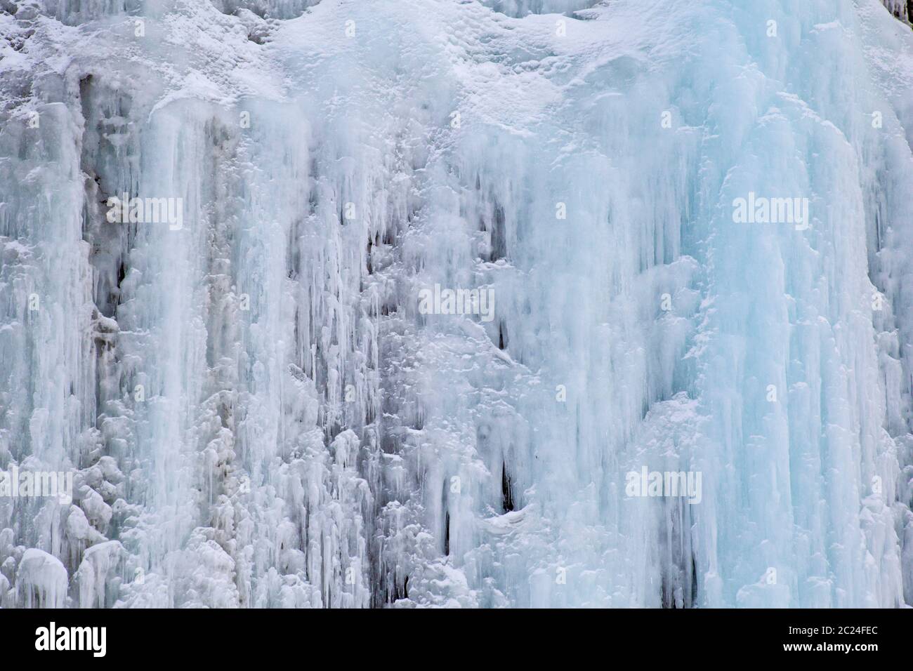 Textur von blauen Eiszapfen auf eisigen Wand aus Felsen Stockfoto
