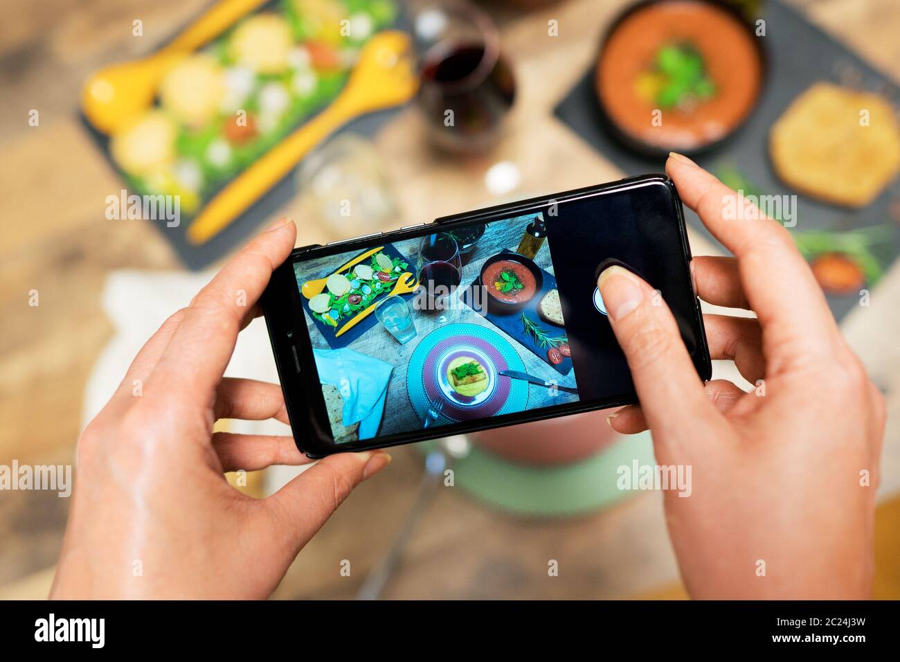 Frau fotografiert Essen per Handy. Stockfoto