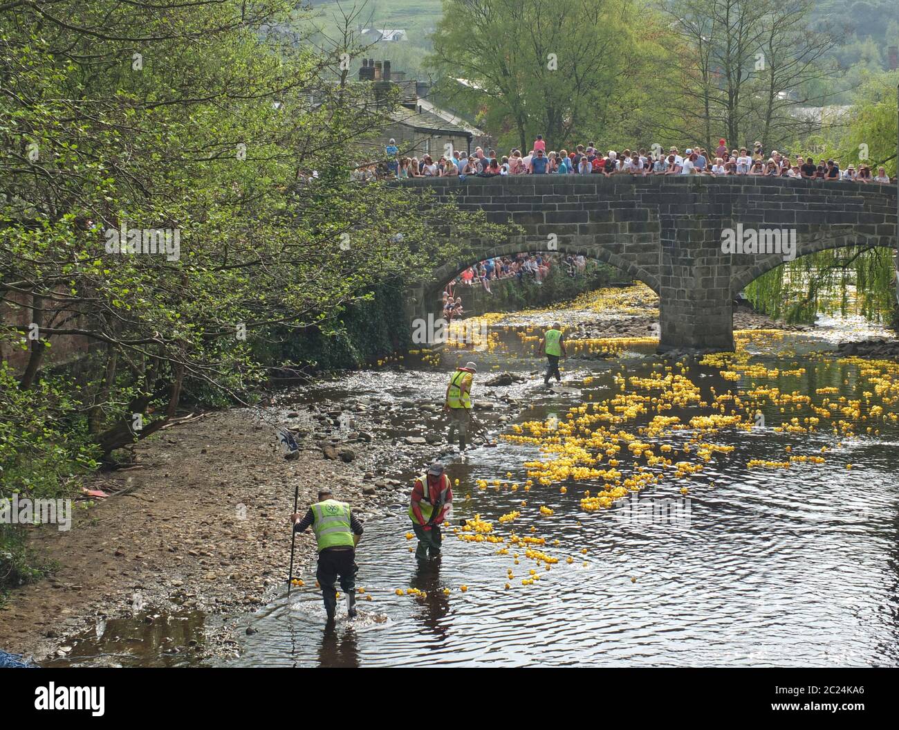 Menschen und Freiwillige beobachten das jährliche karitative Entenrennen am ostermontag in hebden Bridge Stockfoto