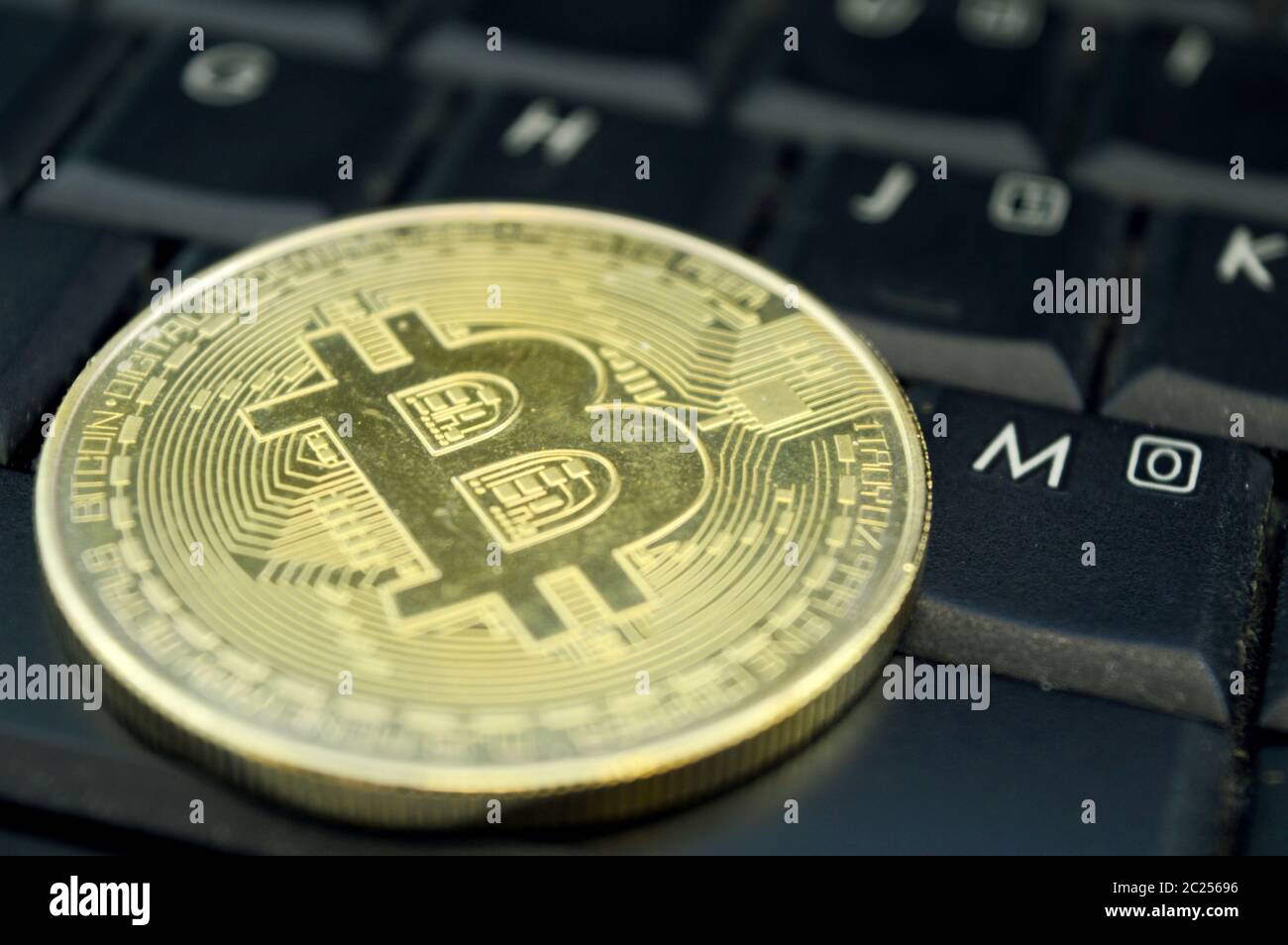 Nahaufnahme eines Stücks Bitcoin auf einer Laptop-Tastatur, um die Kryptowährung zu konzipieren. Stockfoto