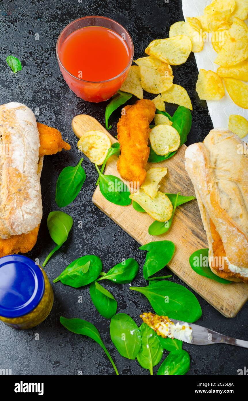 Schnitzel mit pikanter Dip und Spinat in ein rustikales Baguette und hausgemachte Pommes frites Stockfoto