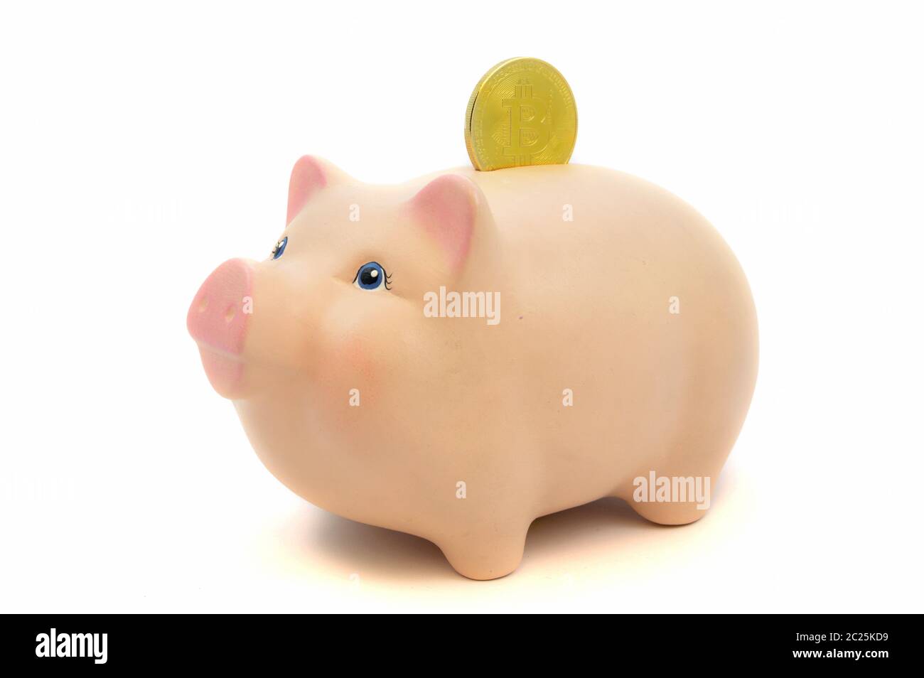 Ein Nahaufnahme-Bild eines goldenen Bitcoin-Stückes, das in ein Sparschwein für Konzepte im Zusammenhang mit dem Kryptowährungsgeschäft deponiert wird. Stockfoto