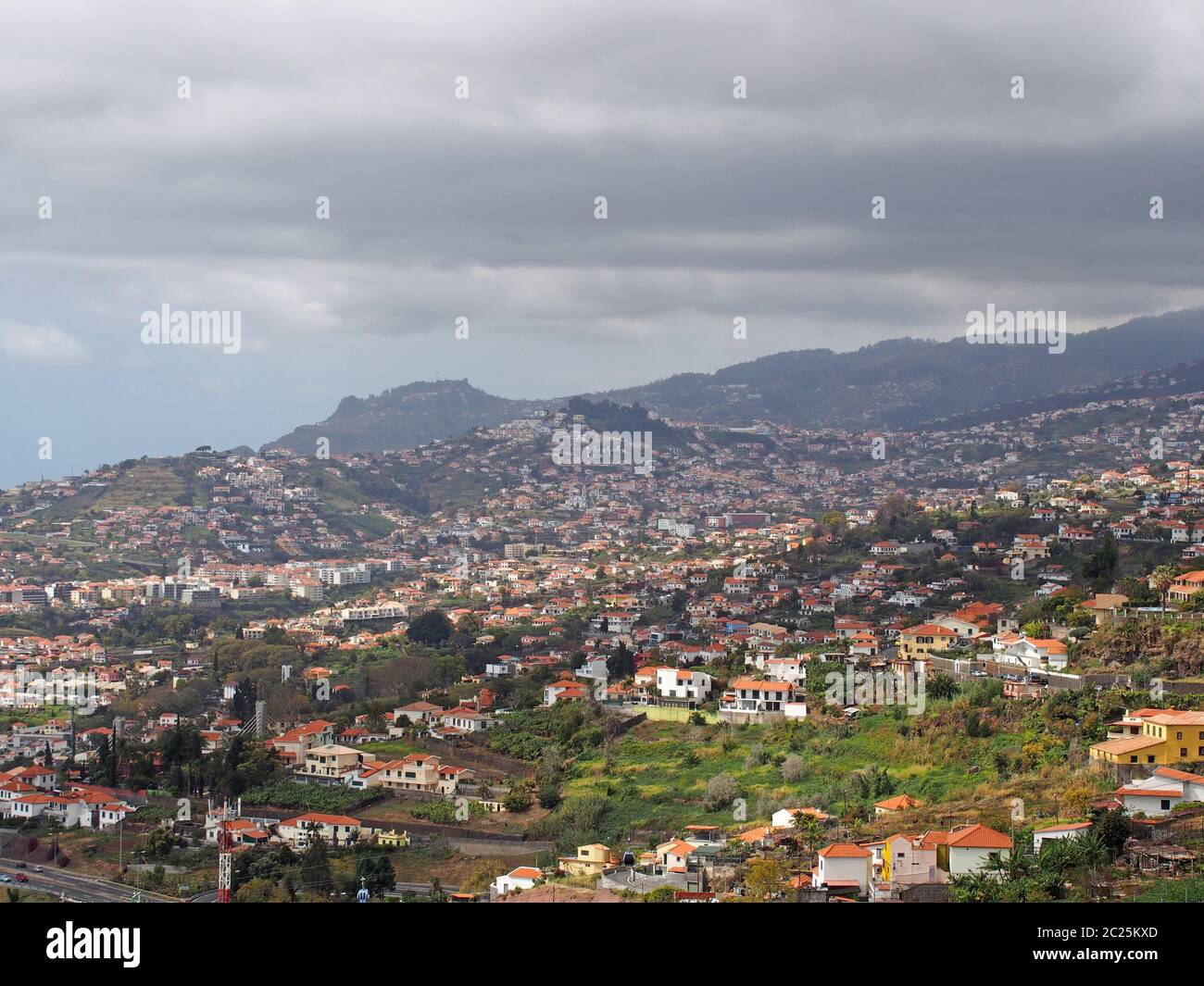 Luftbild Stadtbild Blick auf den Stadtrand von funchal in Madeira mit Bauernhöfen und Häusern mit Bergen und wolkenbehdem Himmel in der Ferne Stockfoto