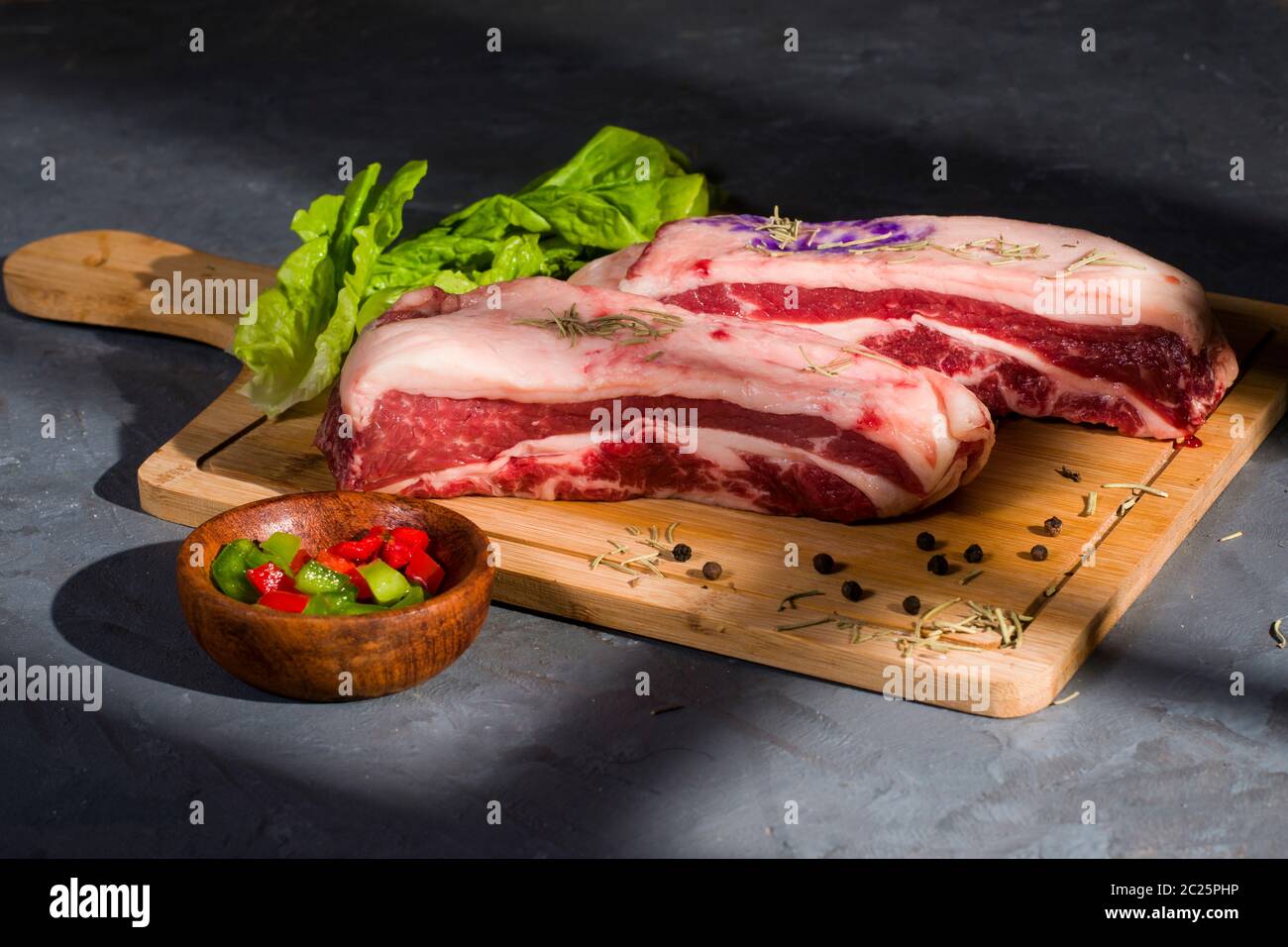 Argentinisches rohes Fleisch auf einem Holztisch mit grünem und re Pfeffer Stockfoto