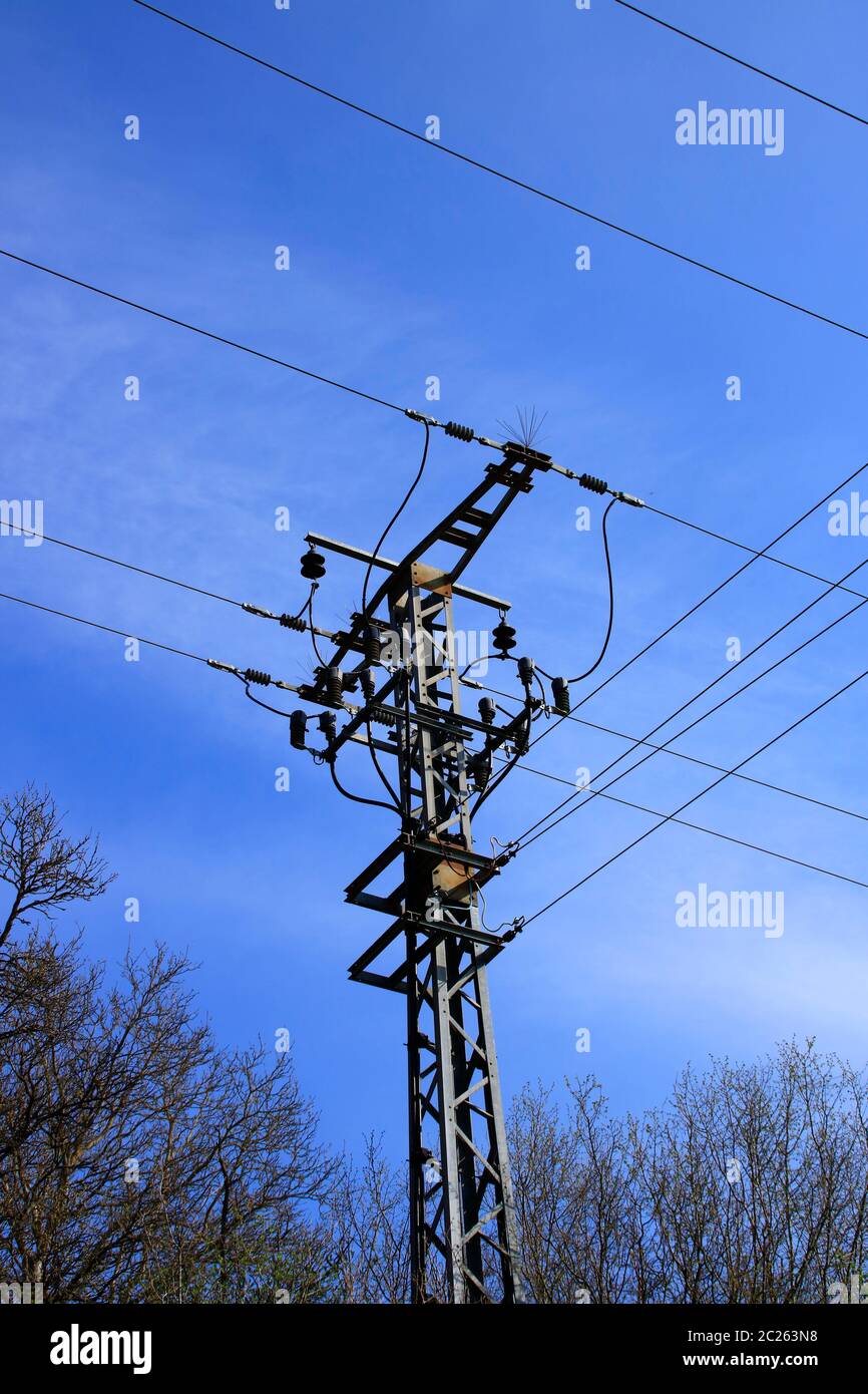 Strommast und Netzkabel vor einem blauen Himmel Stockfoto