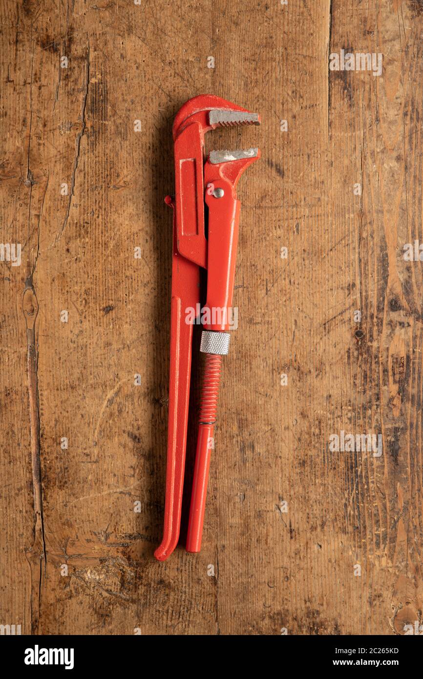Rohrschlüssel Werkzeug auf einem hölzernen Vintage Hintergrund Stockfoto