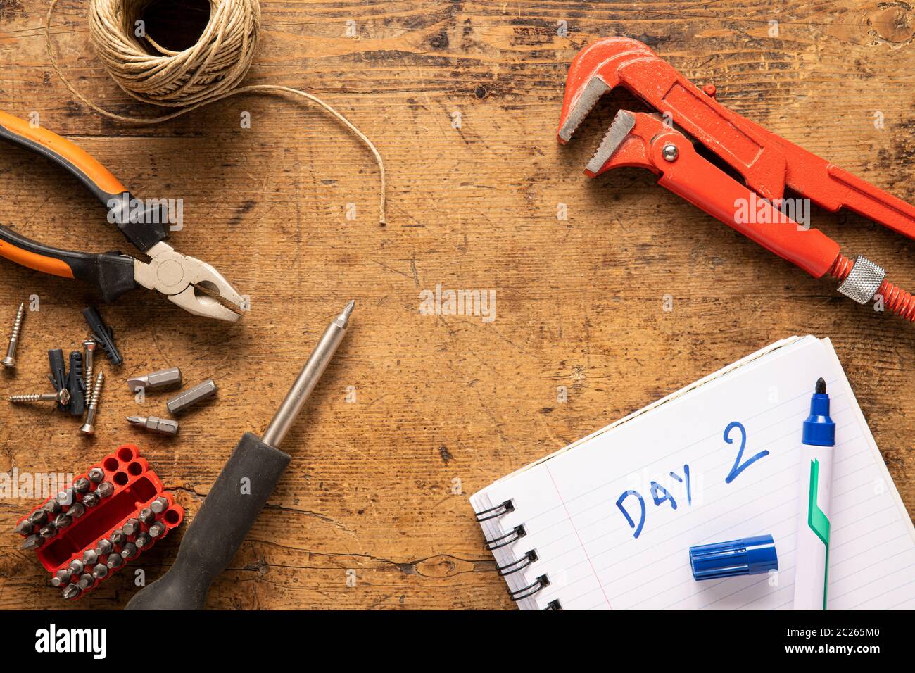 Schraubendreher, Notebook, Schrauben und andere Werkzeuge auf einer Holzoberfläche Stockfoto