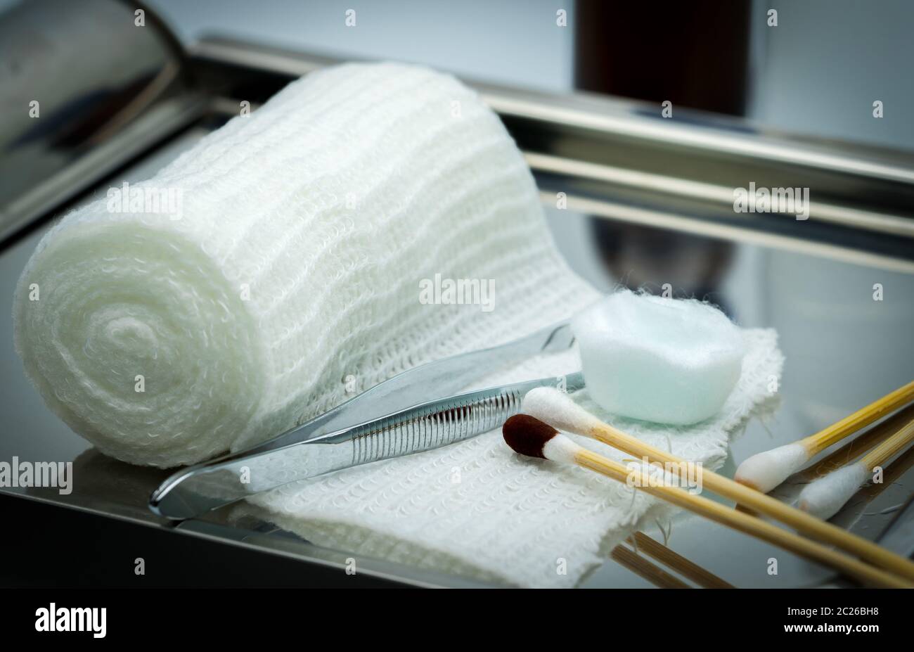 Wundversorgung Abrichten auf Platte aus rostfreiem Stahl. Tupfer mit Alkohol, Wattestäbchen mit Povidon Jod, Pinzette und Bandage entsprechen. Stockfoto