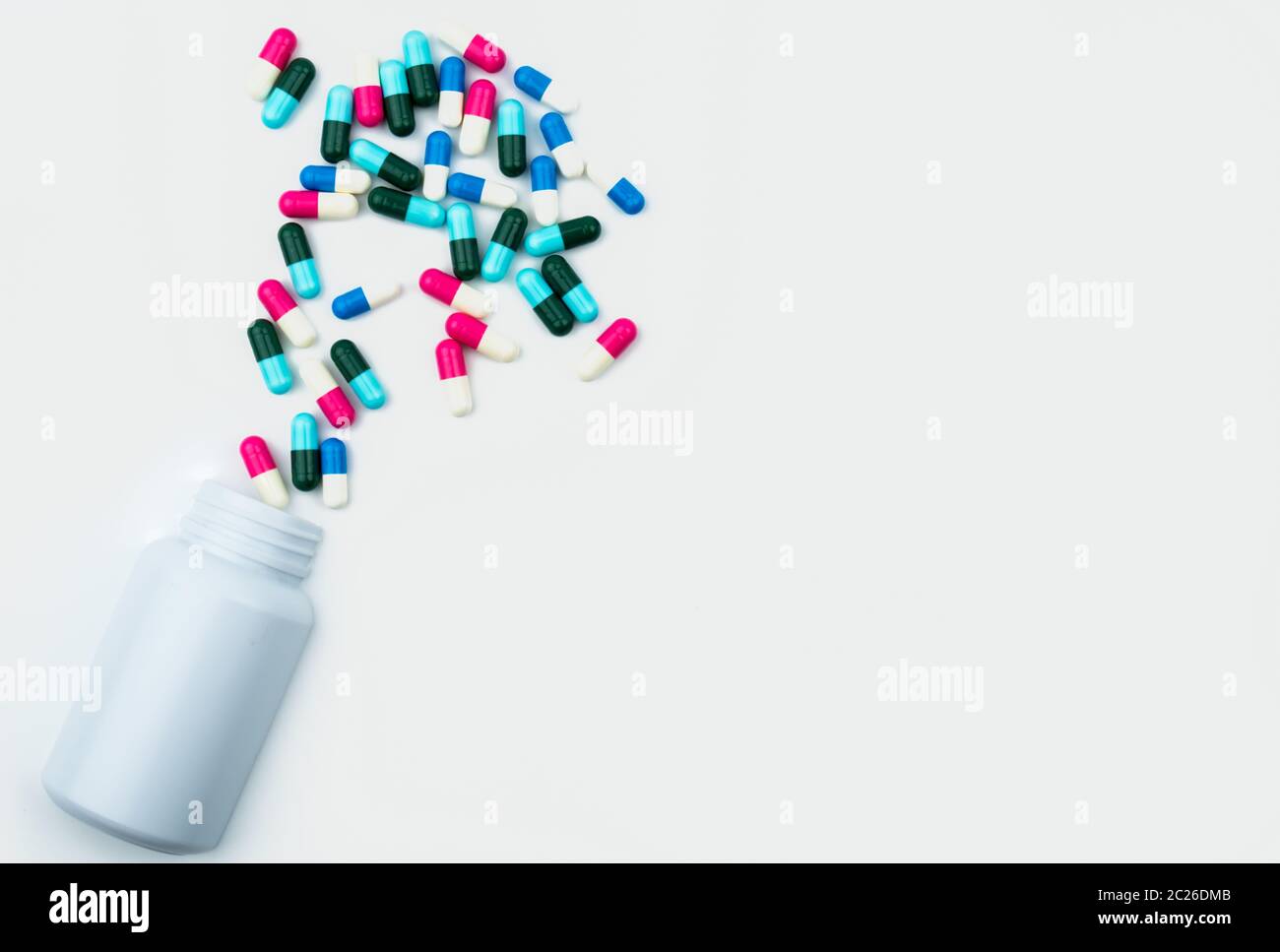 Gießen Antibiotika Kapsel Pillen in die Plastikflasche auf weißem Hintergrund mit Kopie Raum isoliert. Droge, Lagerung, Antibiotikum Drogenkonsum mit angemessenen, Stockfoto