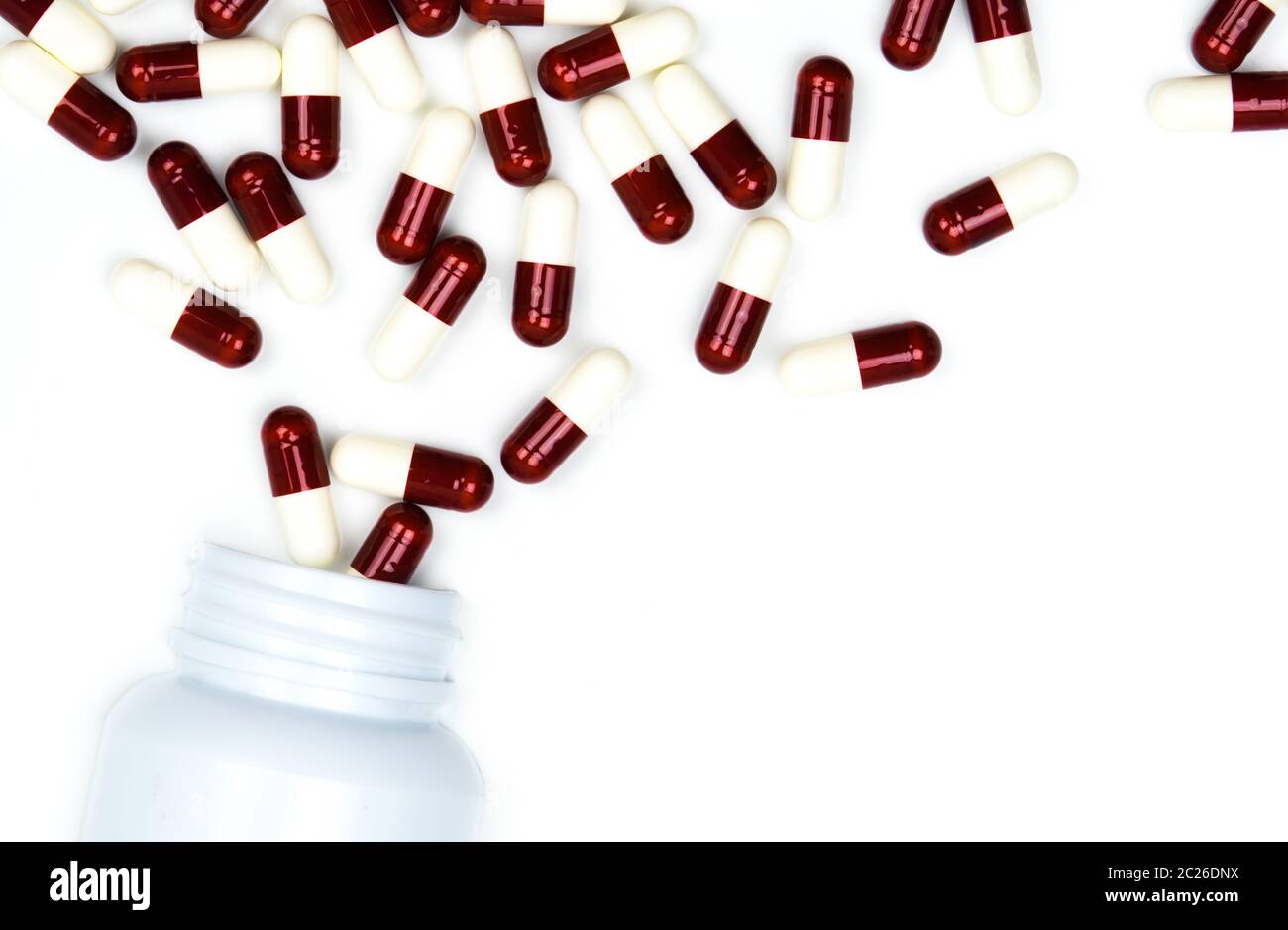Gießen Antibiotika Kapsel Pillen in die Plastikflasche auf weißem Hintergrund mit Kopie Raum isoliert. Droge, Lagerung, Antibiotikum Drogenkonsum mit angemessenen, Stockfoto