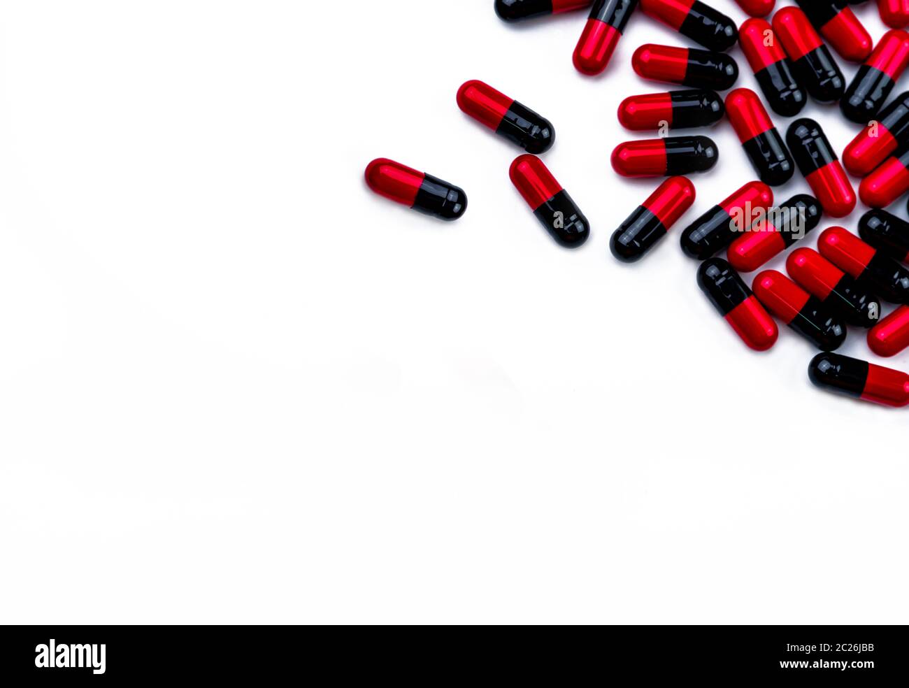 Rot-schwarze Kapsel Pillen auf weißem Hintergrund mit Leerzeichen getrennt für Text. Pharmazie Konzept. Pharmazeutische Industrie. Pharmakologie und Toxikologie Stockfoto