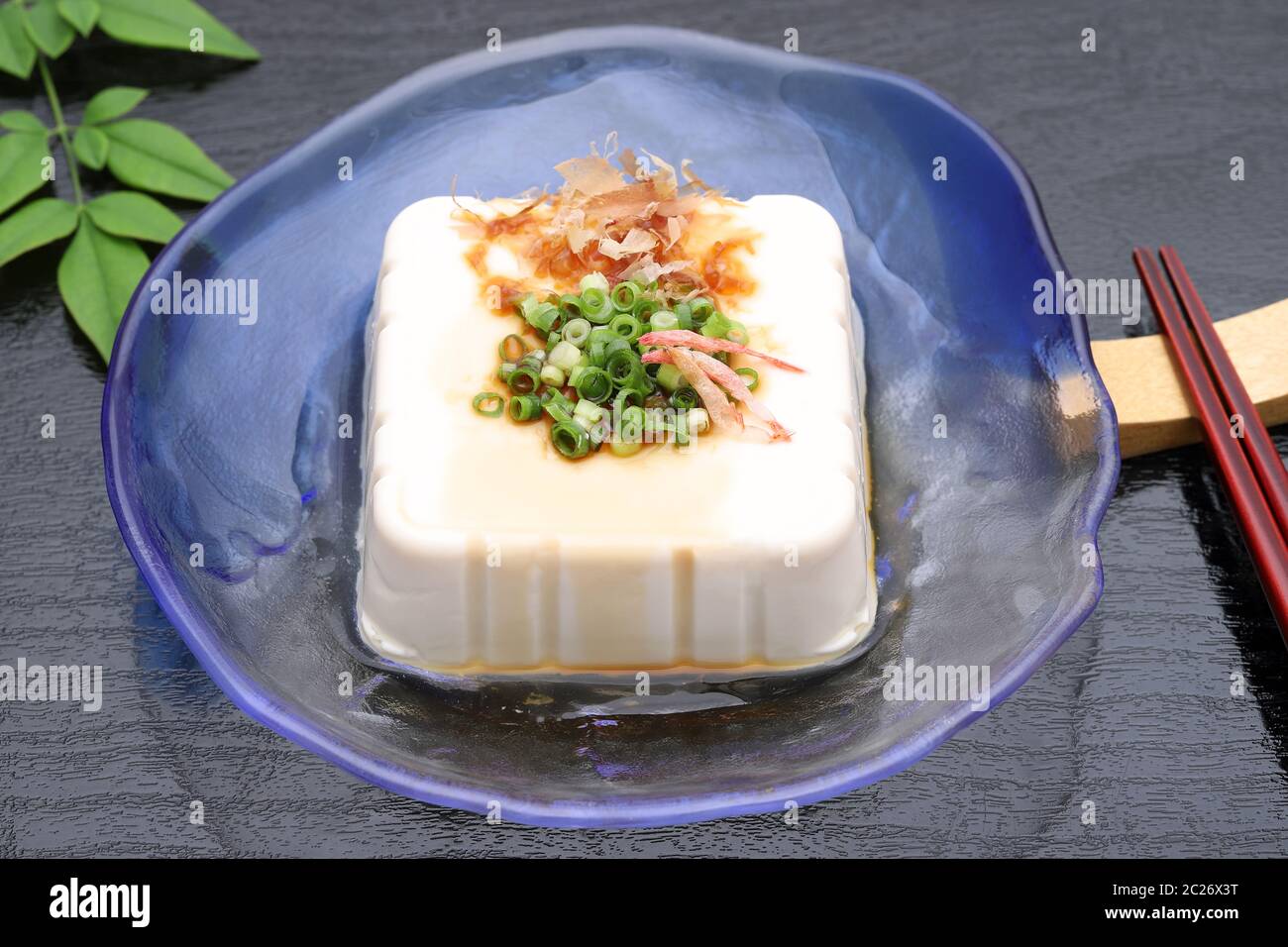 Japanisches Essen, japanischer weicher, kalter Tofu in Glasplatte auf schwarzem Hintergrund Stockfoto