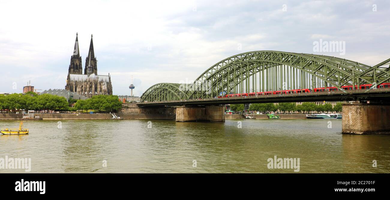Blick auf den Kölner Dom und Hohenzollernbrücke mit Zug passiert, Köln, Deutschland. Banner Panorama. Stockfoto