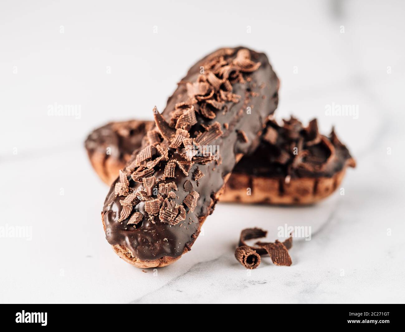 Hausgemachte eclairs mit Schokolade auf weißem Hintergrund. Nahaufnahme ...