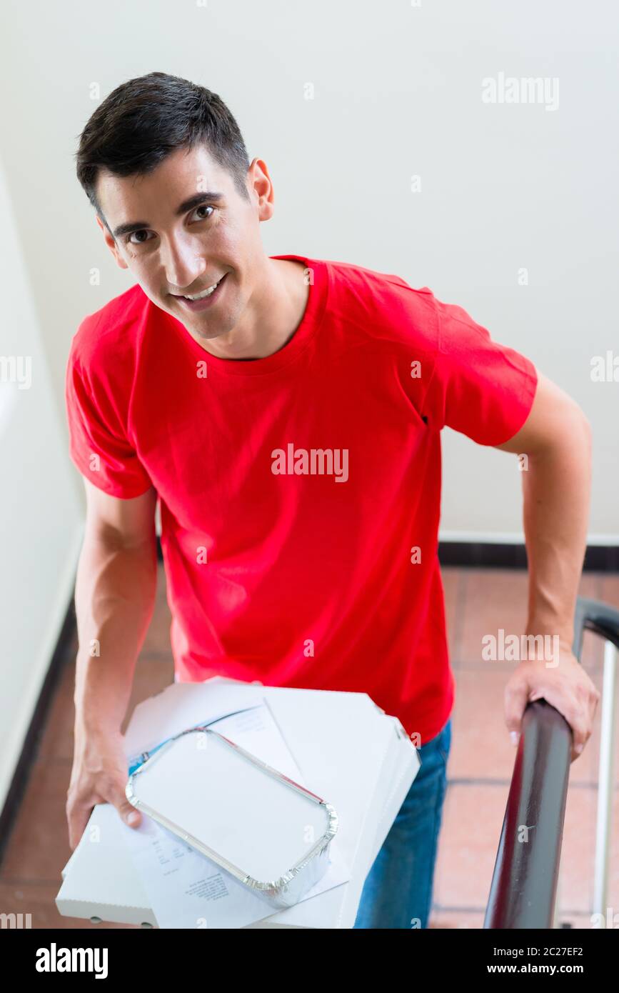 Porträt von glücklichen Pizza Liefermann mit Lebensmitteln Pakete Stockfoto