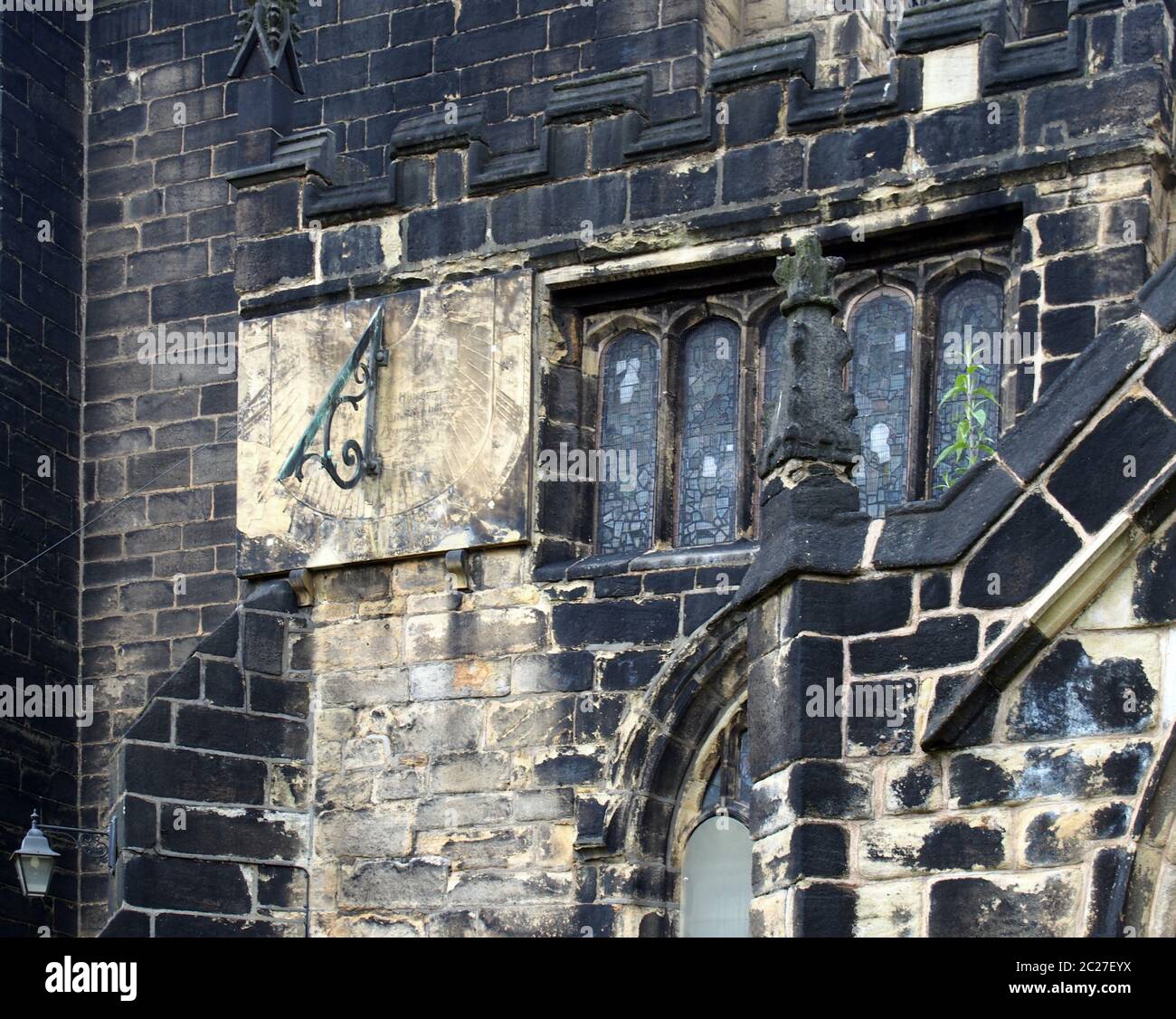 Eine Vollbildaufnahme von alten Steinarbeiten Glasfenster und eine Sonnenuhr auf der mittelalterlichen Kirche von St. johannes dem täufer in Stockfoto