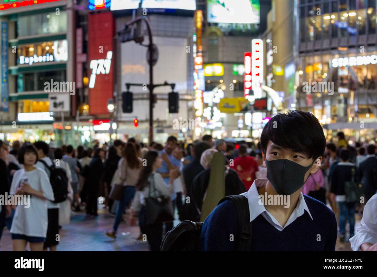 Ein junger Japaner in einer schwarzen Gesichtsmaske auf dem Hachiko-Platz, Shibuya, Tokio, Japan. Stockfoto
