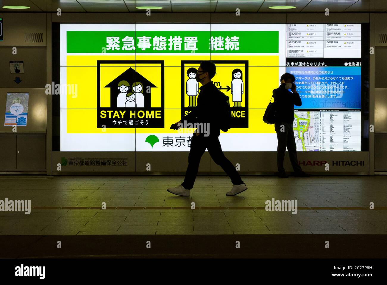 Die Menschen gehen an einem Sprichwort vorbei, bleiben zu Hause und halten die soziale Distanzierung aufrecht, um das Coronavirus im Bahnhof Shinjuku, Tokio, Japan, zu bekämpfen Stockfoto