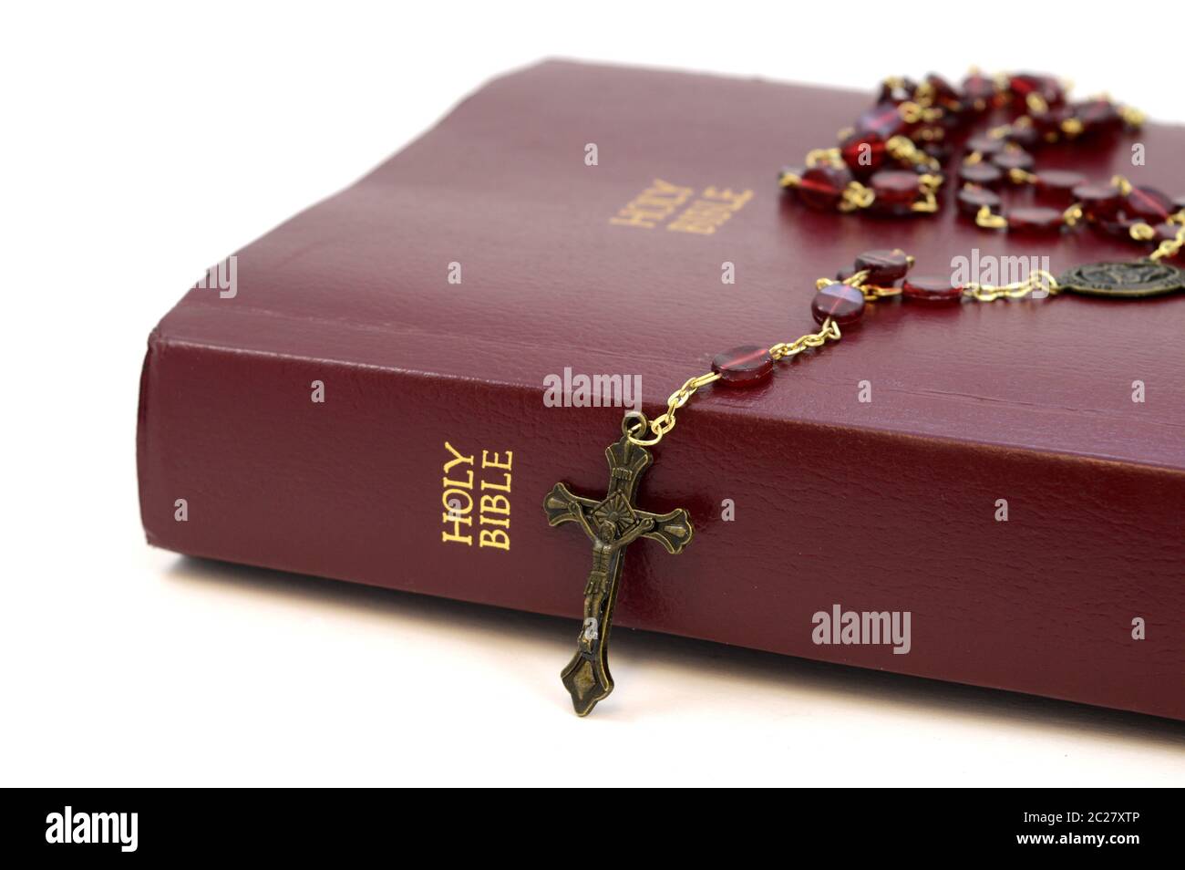 Eine Nahaufnahme der Heiligen Bibel und ein Rosenkranz auf weißem Hintergrund. Stockfoto