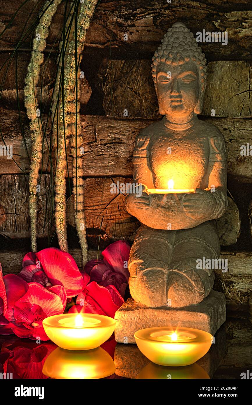 Buddha sitzt im Kerzenlicht Stockfoto