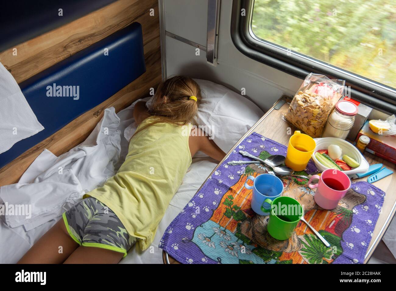 Mädchen schlafen auf dem unteren Regal im Zug Stockfoto