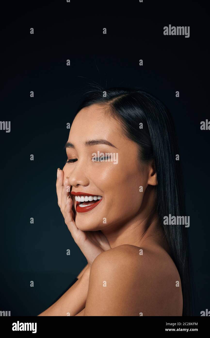 Schöne junge Frau in der Spitze oben mit roten Lippen berühren. Über schwarzen Hintergrund. Kopieren Sie Platz. Stockfoto