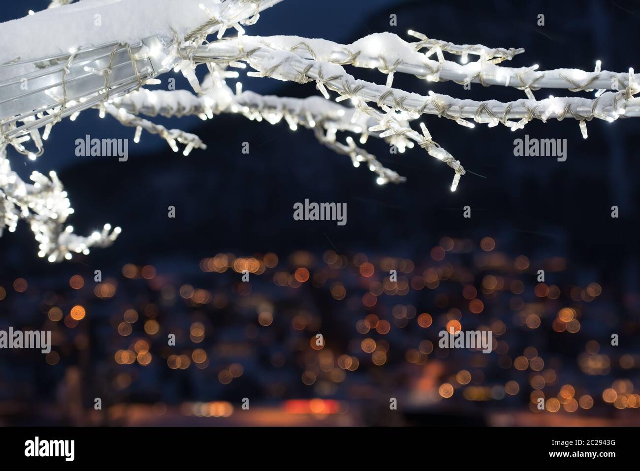 Winter Baum mit Lichtern und Dekorationen mit dem Defokussierten Lichter der Stadt Tromsö Stadt im Hintergrund, Nördliches Norwegen Stockfoto