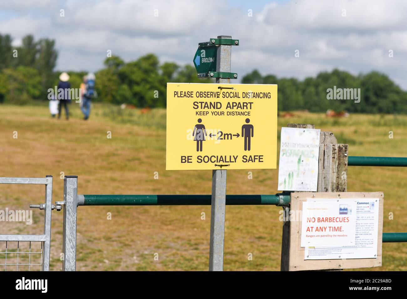 Ein Schild, auf dem Wanderer und Menschen 2 m voneinander entfernt halten sollen, während sie sich entspannen und in öffentlichen Parks in Großbritannien spazieren gehen Stockfoto